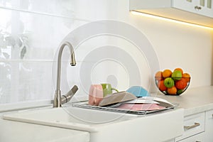 Drying rack with clean dishes over sink