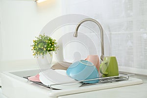 Drying rack with dishes over sink in kitchen