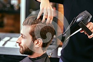 Drying, styling men's hair in a beauty salon photo