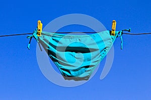 Drying woman swimsuit against blue sky