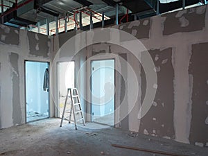 Drywall installation work in progress by construction workers at the construction site.