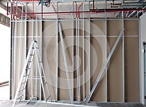 Drywall installation work in progress by construction workers at the construction site.