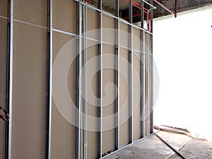 Drywall installation work in progress by construction workers at the construction site.