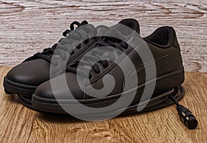 Black leather shoes on wooden surface