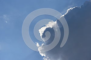 Dark cloud with silver lining against a blue sky