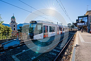 Orange train carriage stopped at Ferrovie Luganesi FLP railway station. Lugano, Canton of Ticino, Switzerland