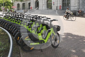 A row of green Go Sharing electrical bikes in a city