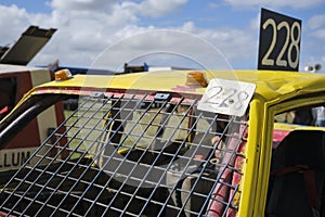 Closeup of a dented yellow stock car photo