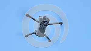 A DJI Mini 3 Pro drone in flight in front of a blue sky