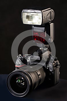 DSLR camera, lens and flash on black