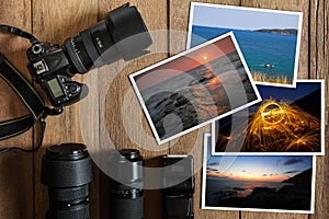 DSLR digital camera,lens,flash and stack of photos on vintage grunge wooden background photo