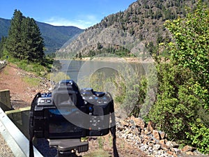 A DSLR Taking a Photo of a Wide Mountain River