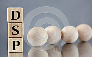 DSP - acronym on wooden cubes on the background of light balls
