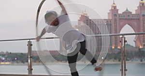 Dubai, Atlantis hotel in the background of a young man spinning in a wheel, 4k