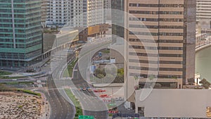 Dubai business bay district with office skyscrapers and traffic on the road intersection aerial all day timelapse.