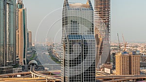 Dubai city skyline panoramic view with metro and cars moving on city's busiest highway aerial morning timelapse