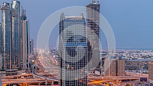 Dubai city skyline panoramic view with metro and cars moving on city's busiest highway aerial night to day timelapse