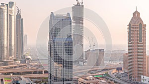 Dubai city skyline panoramic view with metro and cars moving on city's busiest highway aerial timelapse