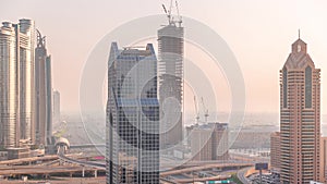 Dubai city skyline panoramic view with metro and cars moving on city's busiest highway aerial timelapse