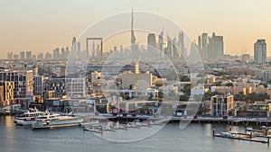 Dubai creek landscape with boats and ship near waterfront and modern buildings in the background during sunset