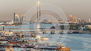 Dubai creek landscape with boats and ship in port and modern buildings in the background during sunset