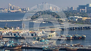 Dubai creek landscape with boats and ship in port and modern buildings in the background during sunset