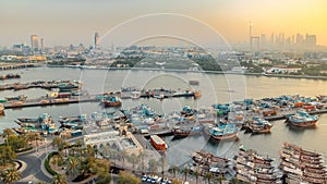 Dubai creek landscape timelapse with boats and ship in port and modern buildings in the background during sunset