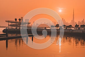 Dubai Creek Marina District at sunset with view of the famous Burj Khalifa tower and other skyscrapers on the other side of the