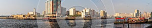 Dubai Creek panorama with river, traditional taxi boats and buildings, United Arab Emirates