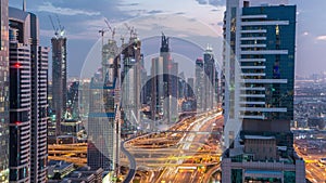 Dubai downtown architecture day to night timelapse. Top view over Sheikh Zayed road with illuminated skyscrapers and