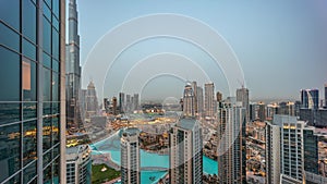 Dubai downtown with fountains and modern futuristic architecture aerial day to night timelapse