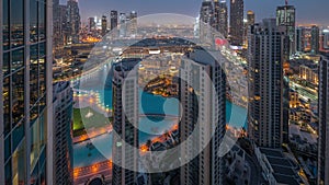 Dubai downtown with fountains and modern futuristic architecture aerial night to day timelapse