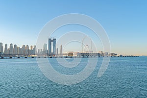 Dubai Downtown skyline with waves on sea beach, United Arab Emirates or UAE. Financial district in travel vacation concept. Urban