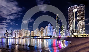 Dubai jumeirah beach with marina skyscrapers in UAE at night.