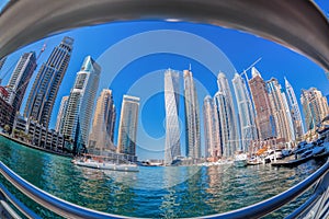 Dubai Marina with boats against skyscrapers in Dubai, United Arab Emirates