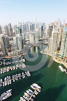 Dubai Marina and Harbour luxury wealth travel with boats yacht in United Arab Emirates from above portrait format