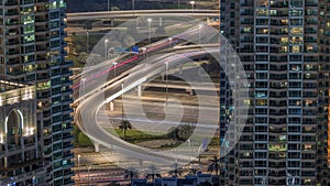 Dubai Marina highway exit between skyscrapers, spaghetti junction aerial night timelapse