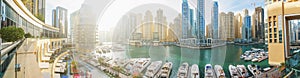 Dubai Marina panorama in morning sunlight, boats and yachts in water canal with modern skyscrapers buildings