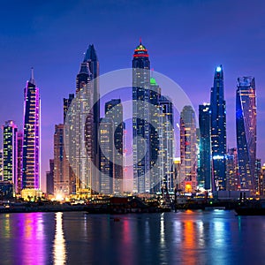 Dubai marina skyline at night with water reflections