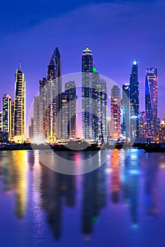 Dubai marina skyline at night with water reflections, United Arab Emirates