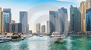 Dubai Marina skyscrapers on background and luxury yacht in water canal, Dubai, UAE