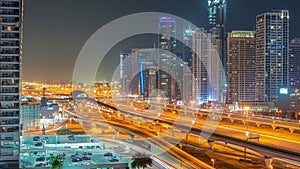 Dubai Marina skyscrapers and Sheikh Zayed road with metro railway aerial all night timelapse, United Arab Emirates