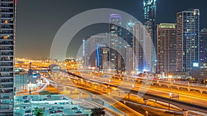 Dubai Marina skyscrapers and Sheikh Zayed road with metro railway aerial all night timelapse, United Arab Emirates