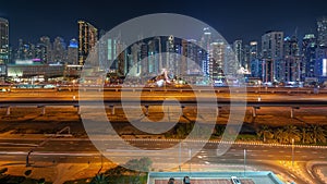 Dubai Marina skyscrapers and Sheikh Zayed road with metro railway aerial night timelapse, United Arab Emirates