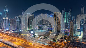 Dubai Marina skyscrapers and Sheikh Zayed road with metro railway aerial night timelapse, United Arab Emirates