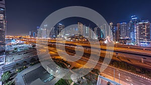 Dubai Marina skyscrapers and Sheikh Zayed road with metro railway aerial night timelapse, United Arab Emirates