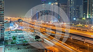 Dubai Marina skyscrapers and Sheikh Zayed road with metro railway aerial night timelapse, United Arab Emirates