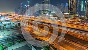 Dubai Marina skyscrapers and Sheikh Zayed road with metro railway aerial night timelapse, United Arab Emirates