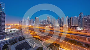 Dubai Marina skyscrapers and Sheikh Zayed road with metro railway aerial night to day , United Arab Emirates