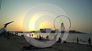 Dubai marina Sunset beach over Bluewaters island with modern ferris wheel